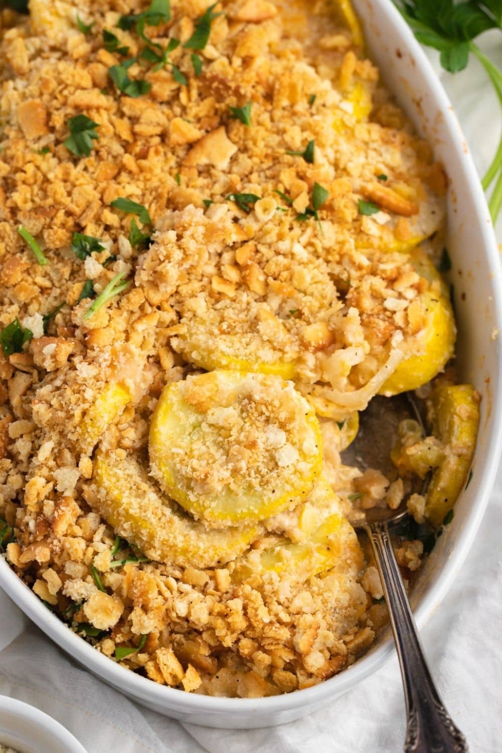 Paula Deen’s Squash Casserole Made With Rounded Cut Summer Squash and  Crushed Butter Crackers, Prepared on a Baking Dish With Spoon Dipped on It for Serving